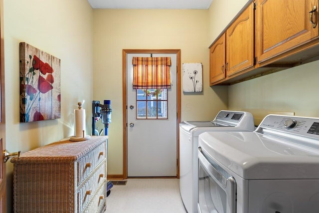 laundry room featuring washer and dryer and cabinets