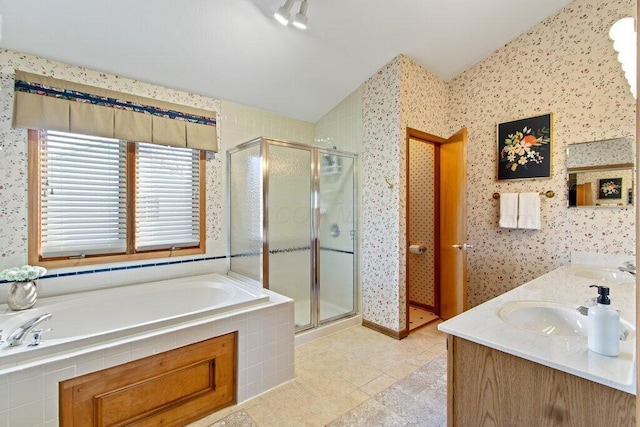 bathroom featuring vanity, separate shower and tub, and vaulted ceiling