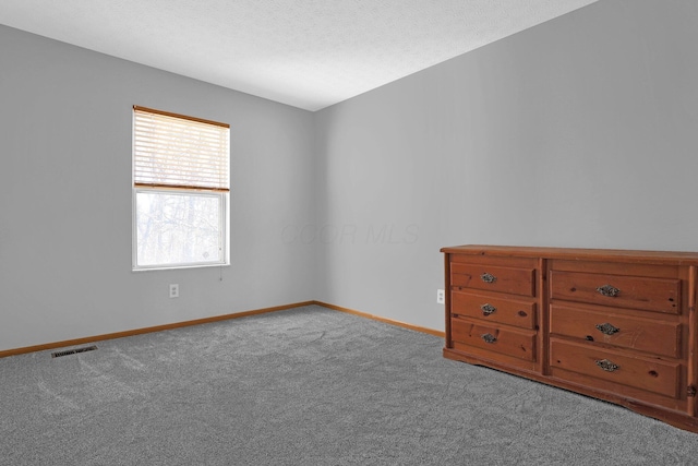 carpeted empty room with a textured ceiling