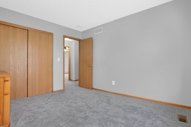 unfurnished bedroom featuring light colored carpet and a closet