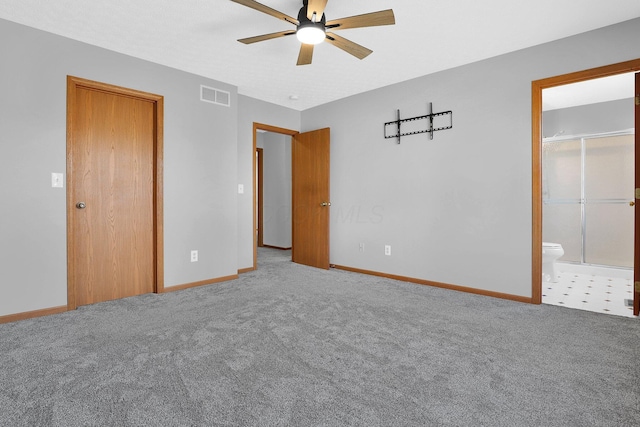 unfurnished bedroom featuring ceiling fan, carpet floors, and ensuite bath