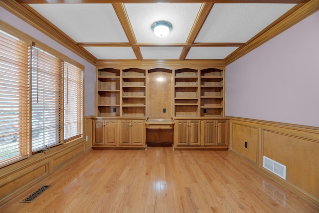 unfurnished office featuring built in features, ornamental molding, a textured ceiling, and light wood-type flooring