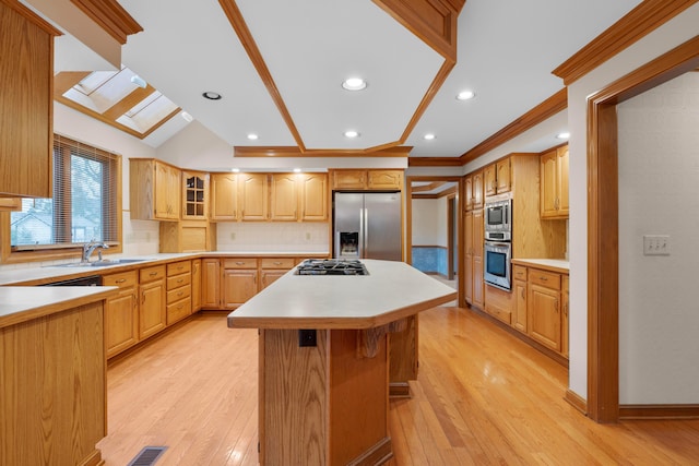 kitchen with a center island, sink, stainless steel appliances, and light hardwood / wood-style flooring