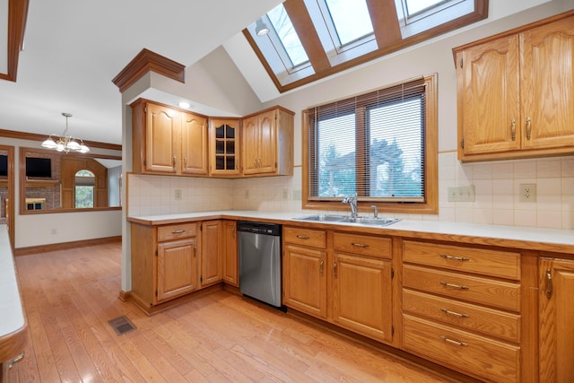 kitchen with sink, stainless steel dishwasher, a notable chandelier, pendant lighting, and light hardwood / wood-style floors