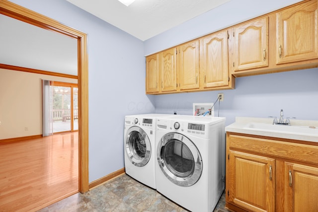 washroom with separate washer and dryer, sink, cabinets, and light wood-type flooring