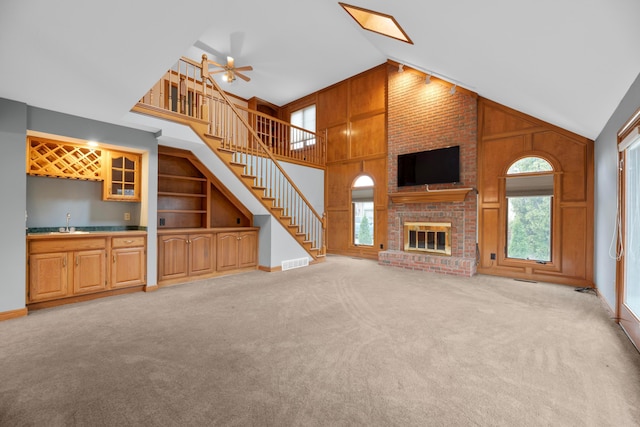 unfurnished living room featuring a wealth of natural light, a fireplace, and high vaulted ceiling