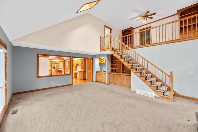 unfurnished living room featuring ceiling fan, carpet floors, and high vaulted ceiling