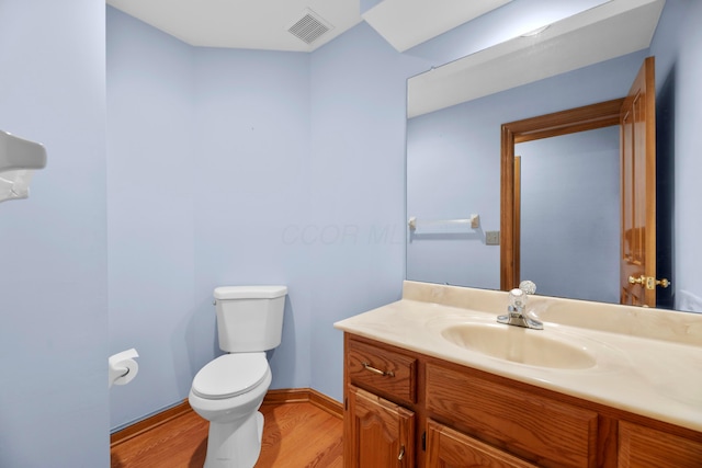 bathroom with hardwood / wood-style floors, vanity, and toilet