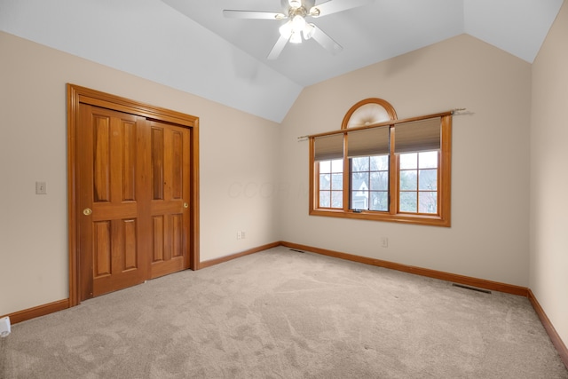 unfurnished bedroom featuring ceiling fan, light carpet, and lofted ceiling