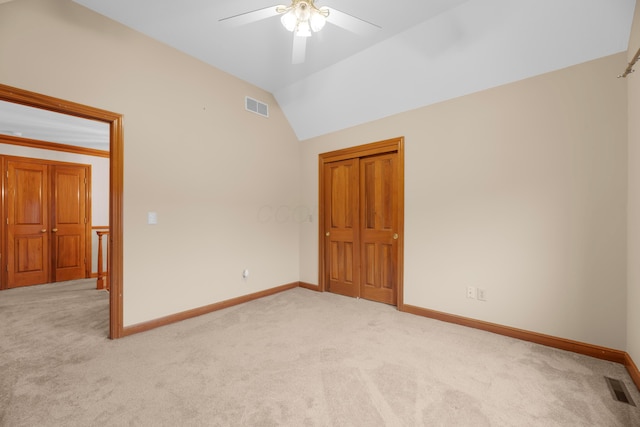 carpeted spare room featuring ceiling fan and lofted ceiling