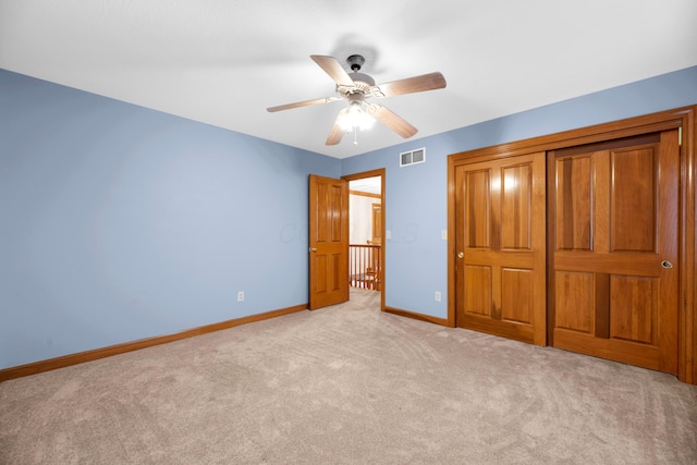 unfurnished bedroom featuring ceiling fan, a closet, and light carpet