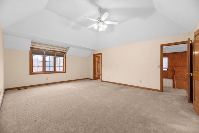 unfurnished room featuring light colored carpet, vaulted ceiling, and ceiling fan