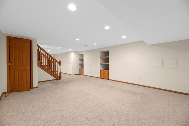 basement featuring light carpet and built in features