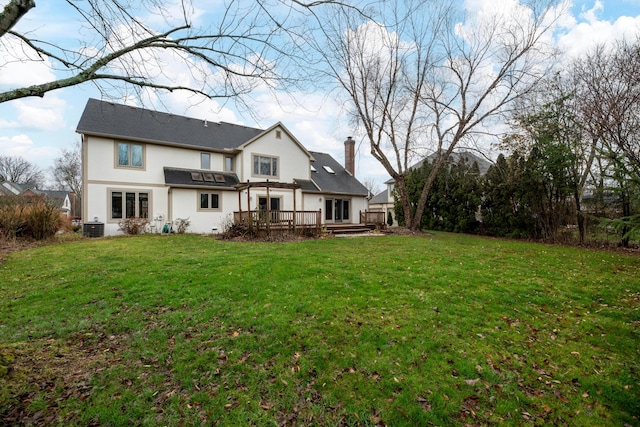 rear view of property with a yard, central AC unit, and a deck