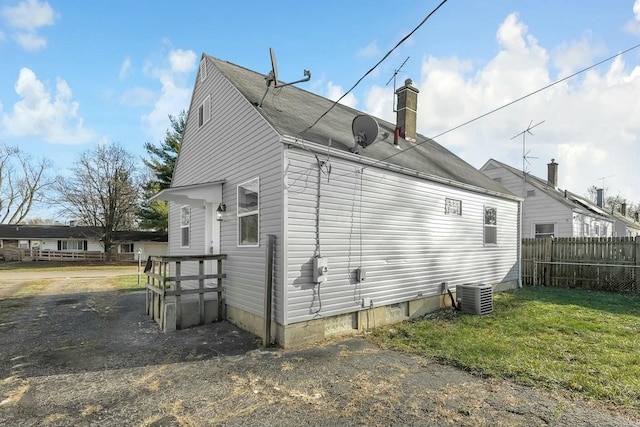 view of property exterior featuring cooling unit and a yard