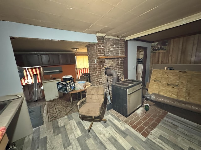 interior space with light hardwood / wood-style floors, a wood stove, and wood walls