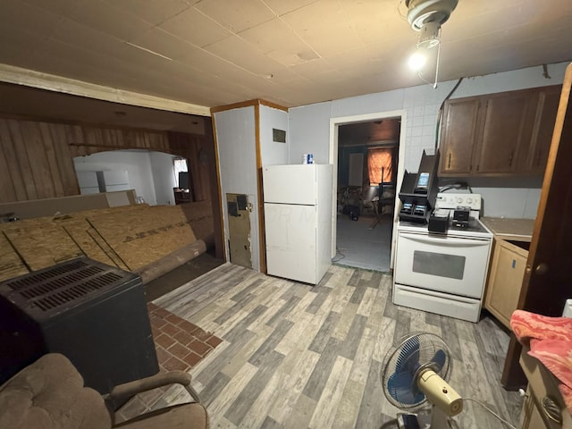 kitchen with light wood-type flooring, white appliances, and wooden walls