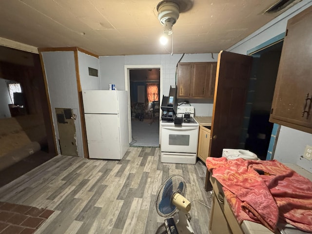 kitchen featuring white appliances and light hardwood / wood-style flooring