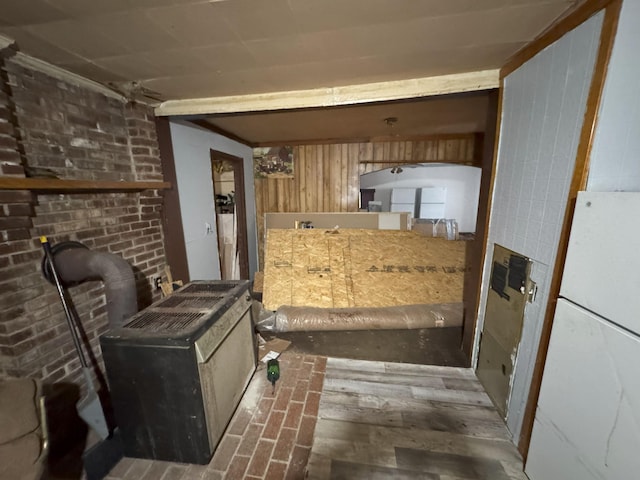 interior space featuring a wood stove, wood walls, dark wood-type flooring, and white refrigerator