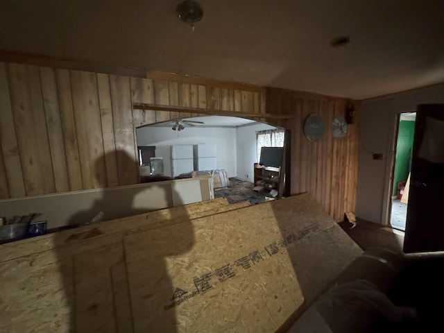 miscellaneous room featuring ceiling fan and wood walls