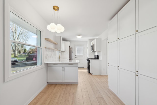 kitchen featuring appliances with stainless steel finishes, decorative light fixtures, sink, white cabinets, and decorative backsplash