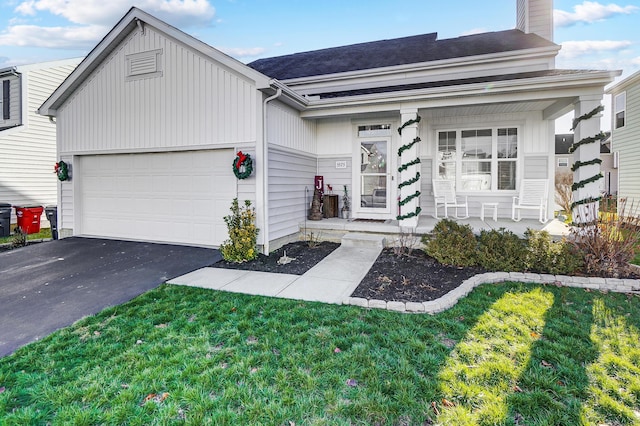 view of front facade featuring a front yard, a porch, and a garage