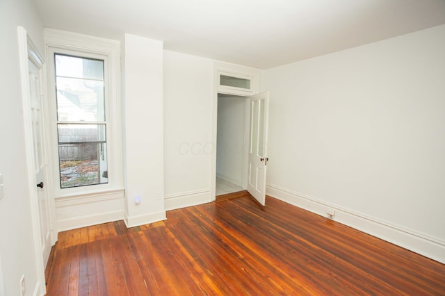 unfurnished bedroom featuring dark wood-type flooring and multiple windows