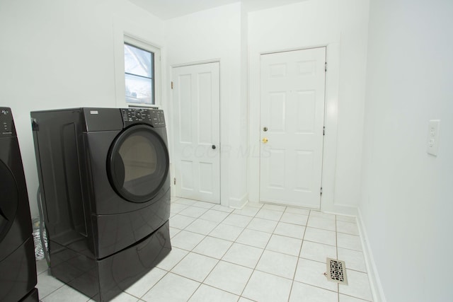 laundry room featuring washer and clothes dryer and light tile patterned floors