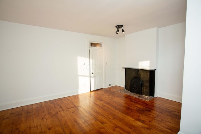 unfurnished living room with hardwood / wood-style flooring and a tile fireplace