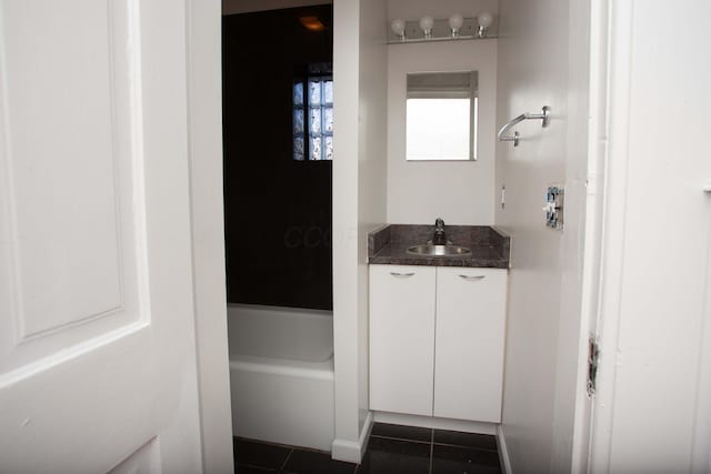 bathroom with tile patterned floors, a washtub, and vanity