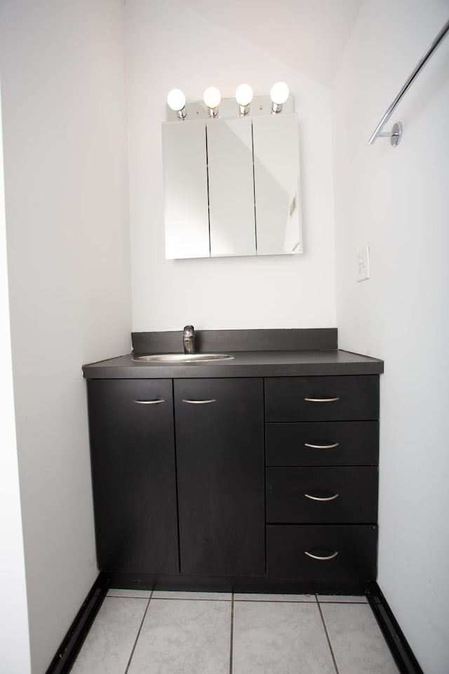 bathroom featuring tile patterned floors, vanity, and vaulted ceiling