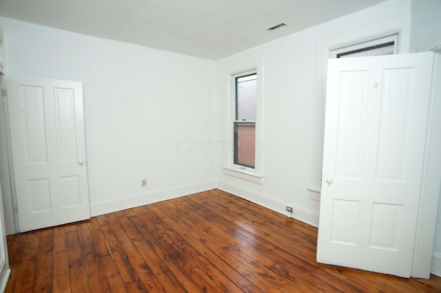 unfurnished bedroom with dark wood-type flooring