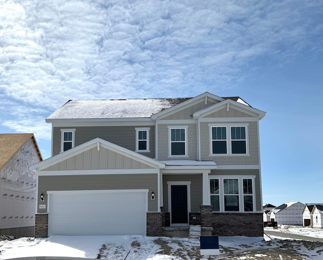 craftsman house with a garage, brick siding, and board and batten siding