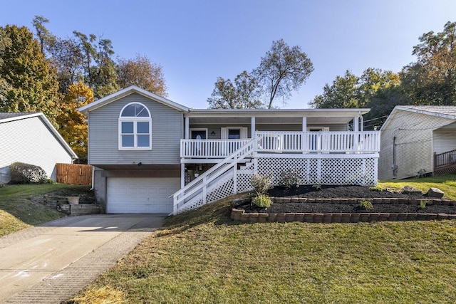 view of front facade featuring a garage, concrete driveway, covered porch, stairs, and a front yard