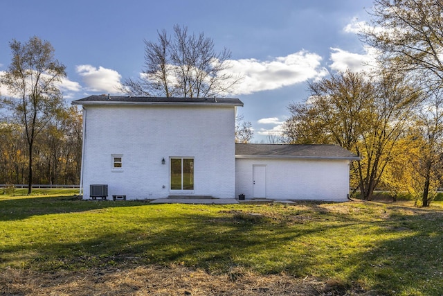 back of property featuring central AC and a yard