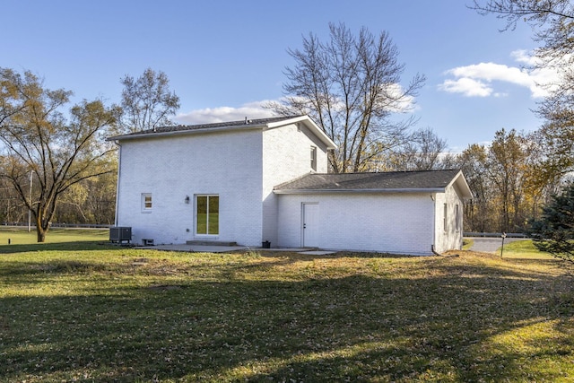 back of house featuring central AC unit and a lawn