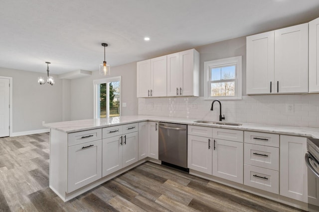 kitchen featuring pendant lighting, dishwasher, sink, white cabinets, and kitchen peninsula