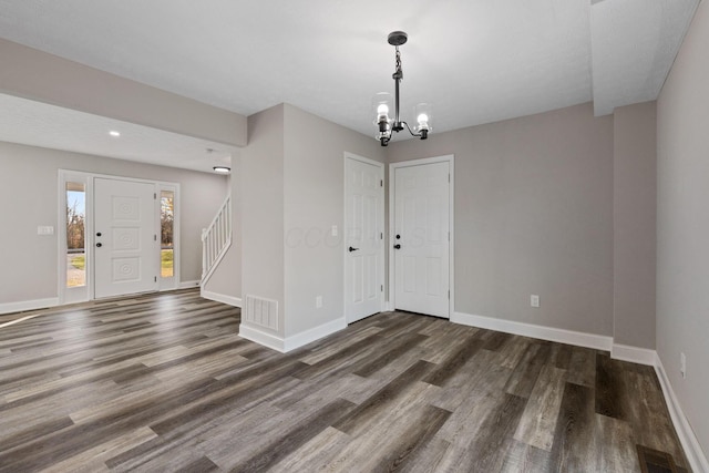 foyer with an inviting chandelier and dark hardwood / wood-style flooring