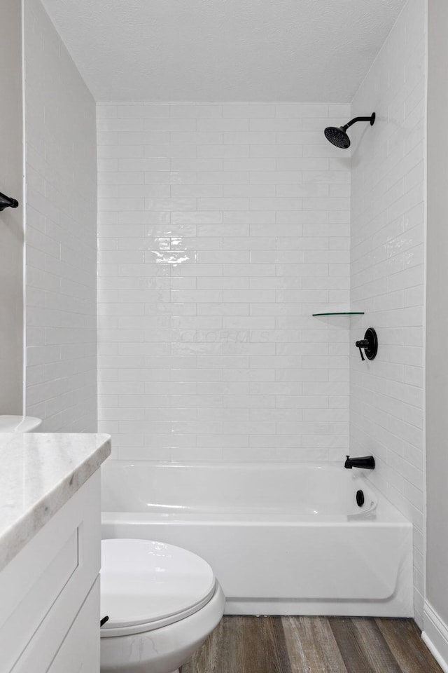 full bathroom with vanity, tiled shower / bath, wood-type flooring, and toilet