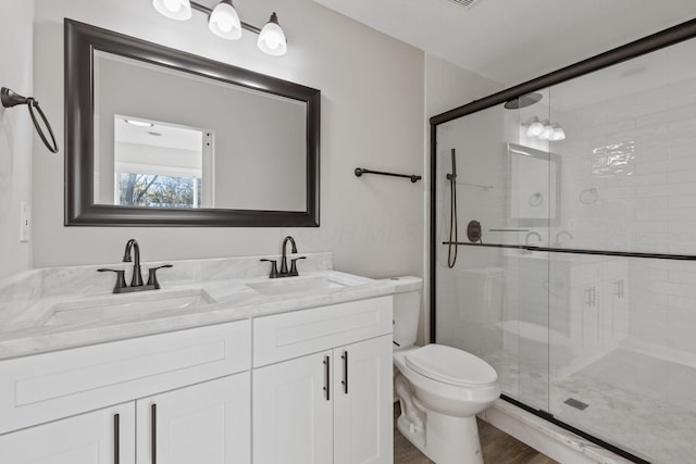 bathroom featuring an enclosed shower, vanity, and toilet