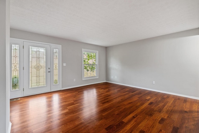 spare room with hardwood / wood-style floors and a textured ceiling