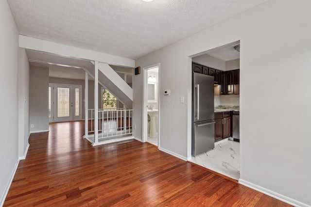 unfurnished room with a textured ceiling and dark hardwood / wood-style flooring