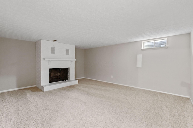 unfurnished living room featuring carpet flooring, a textured ceiling, and a fireplace