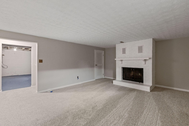 unfurnished living room with carpet floors, a fireplace, and a textured ceiling