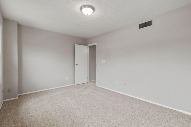 empty room featuring carpet floors and a textured ceiling