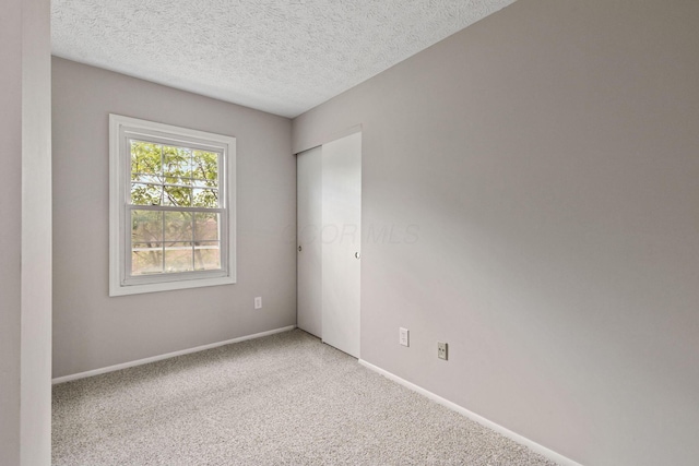 empty room with carpet and a textured ceiling