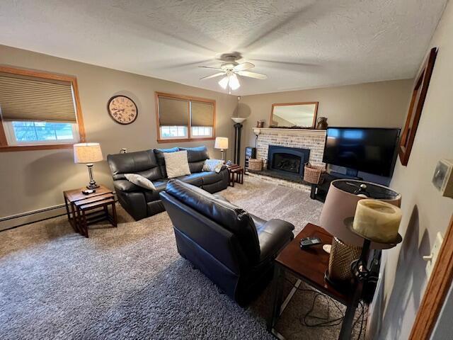 living room featuring carpet flooring, a healthy amount of sunlight, and a textured ceiling