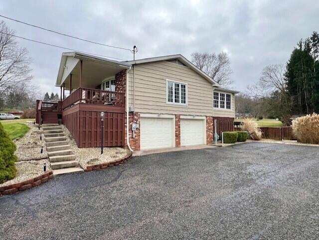 view of property exterior featuring a garage and a wooden deck