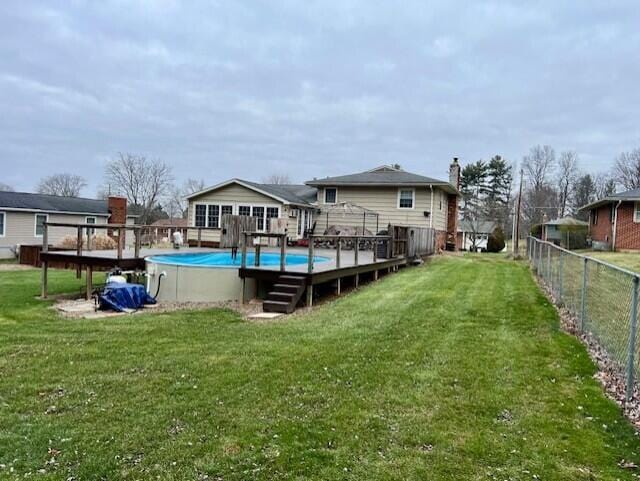 exterior space with a pool side deck and a lawn