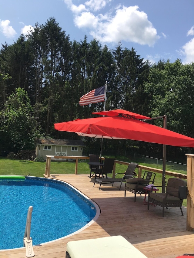 view of swimming pool featuring a yard and a deck